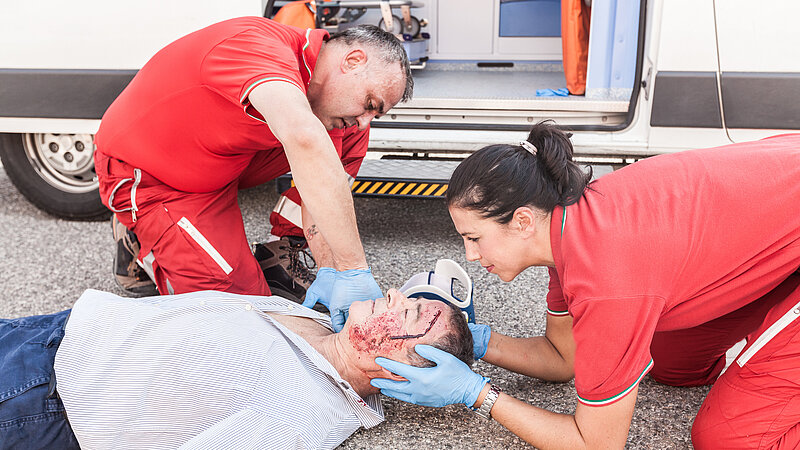 Rettungssanitäter leisten Erste Hilfe an verletztem Mann